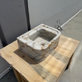 Oval Calacatta Gold marble sink with compact design and warm gold veining
