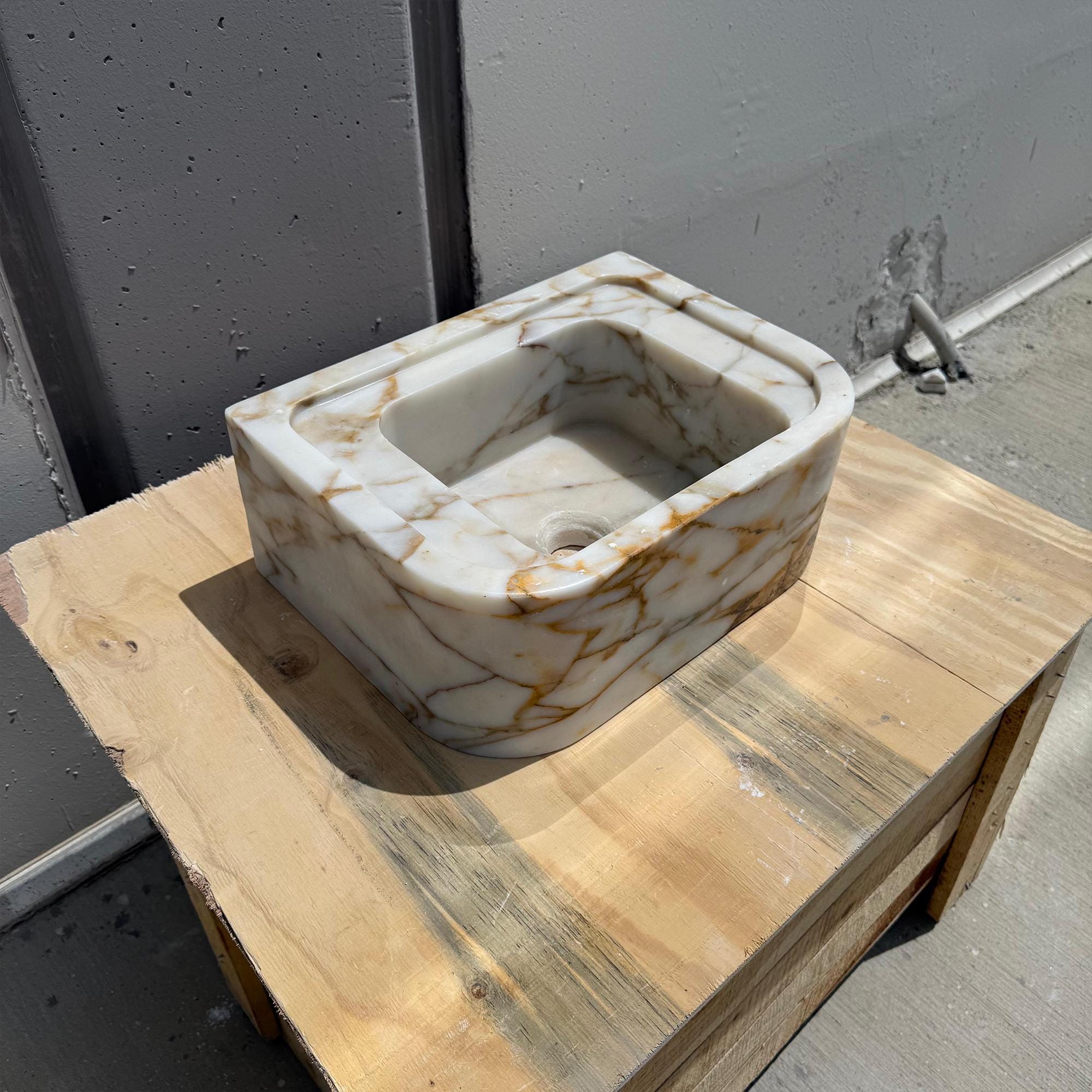 Handcrafted marble vanity sink in creamy white with golden veins