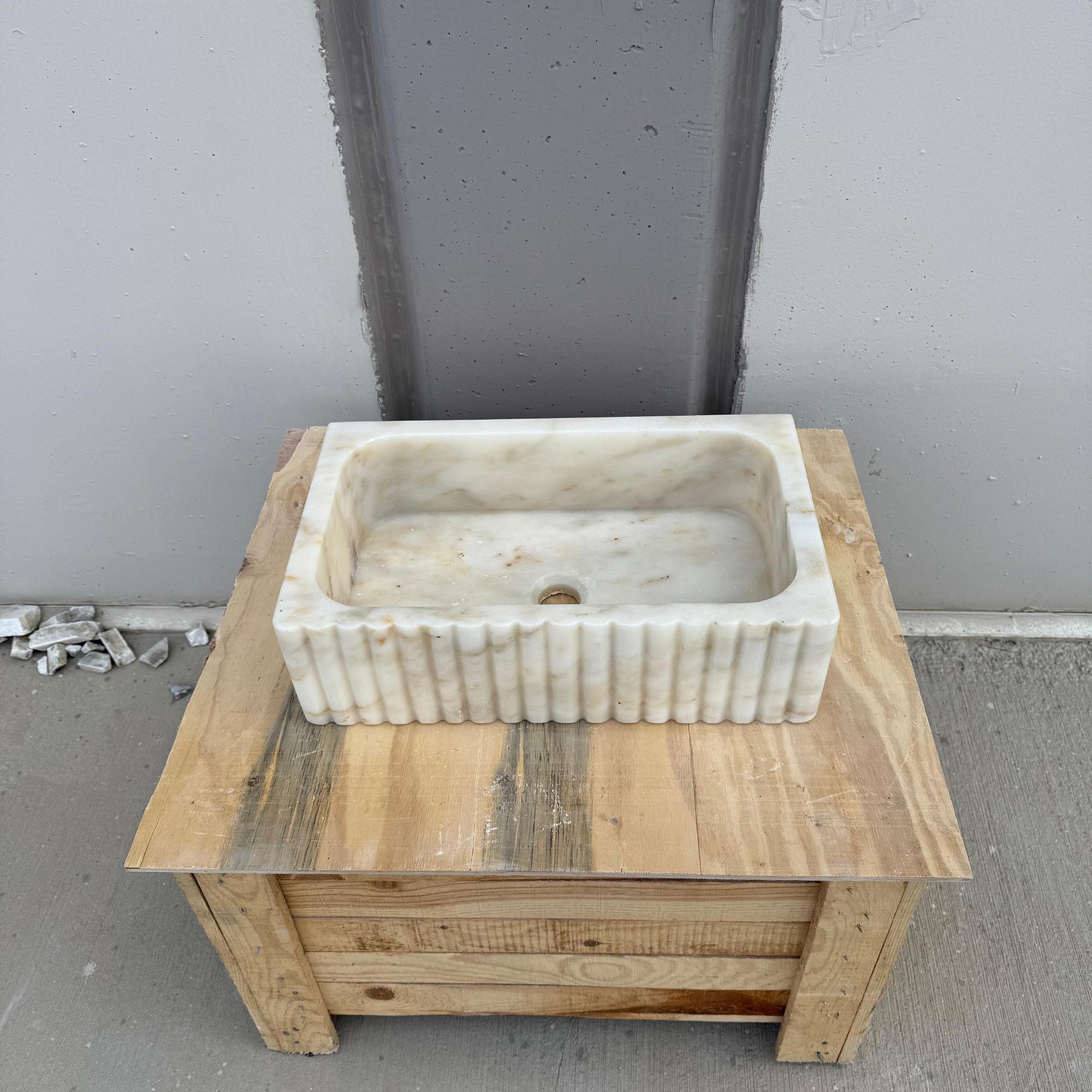 Luxurious countertop marble basin in creamy gold tones.