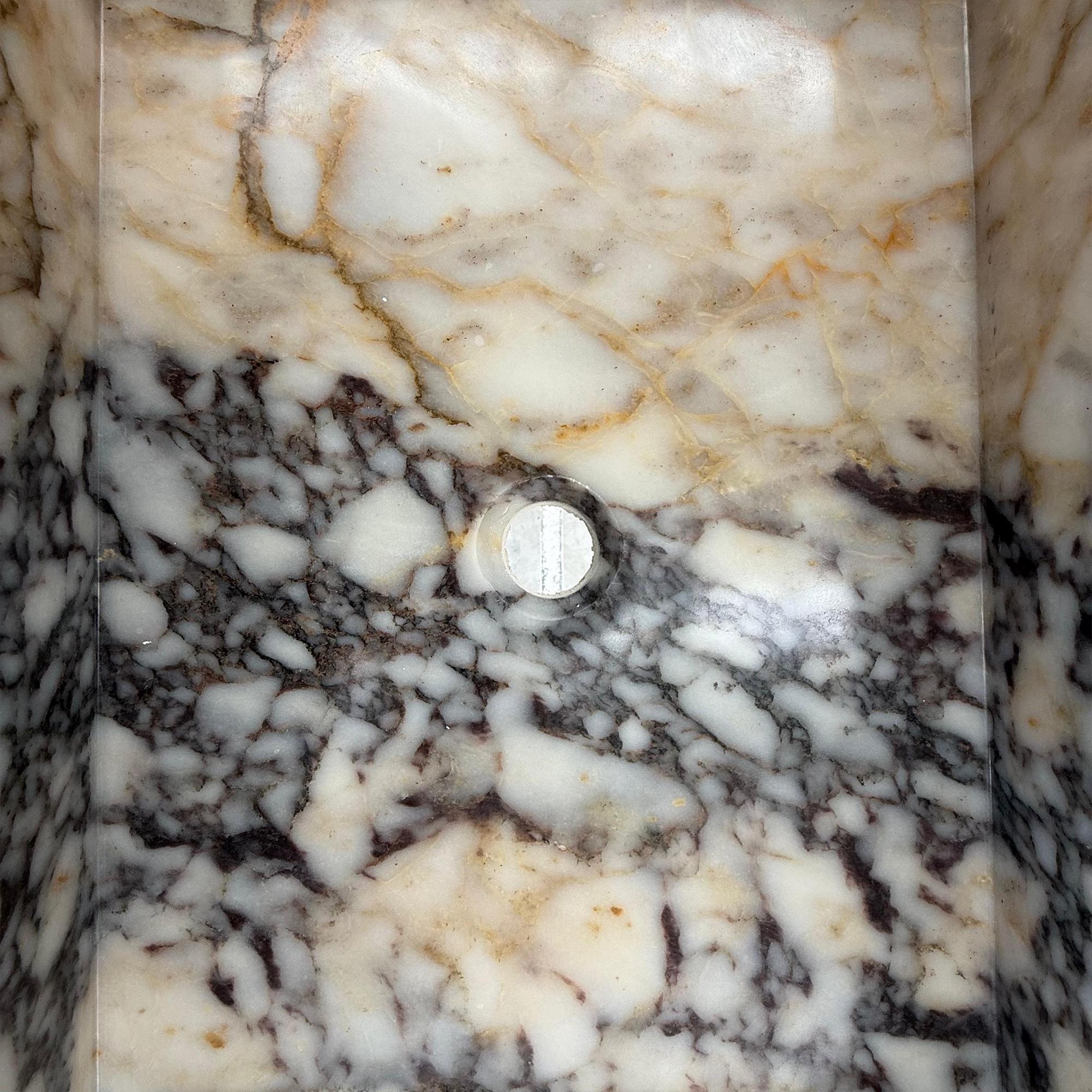 Calacatta Viola bathroom vanity with a thick marble backsplash and modern silhouette.