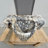 Fluted Calacatta Viola marble sink with sculpted oval basin and bold veining