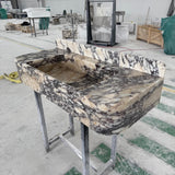 A luxurious Calacatta Viola marble sink featuring a sculpted integrated backsplash.