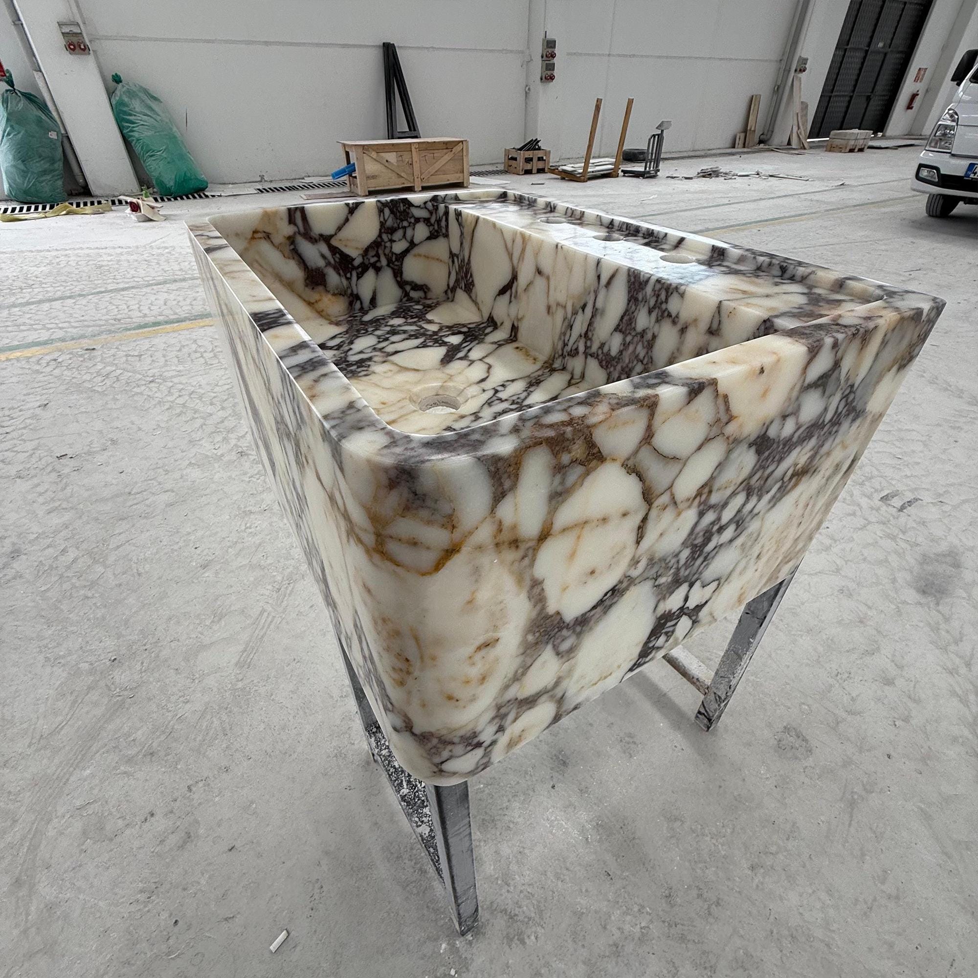 Modern bathroom basin in luxury marble with integrated stone shelf