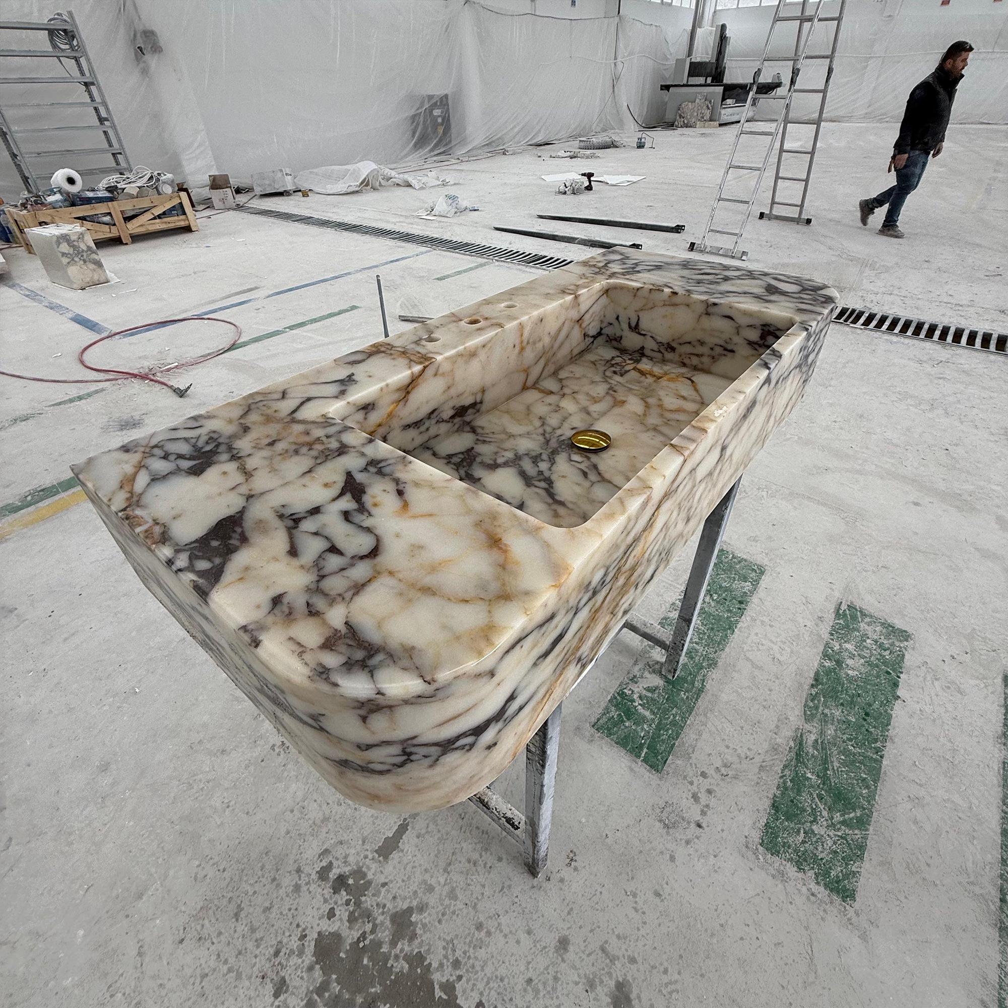 A detailed view of a custom sink carved from premium Calacatta Viola marble.