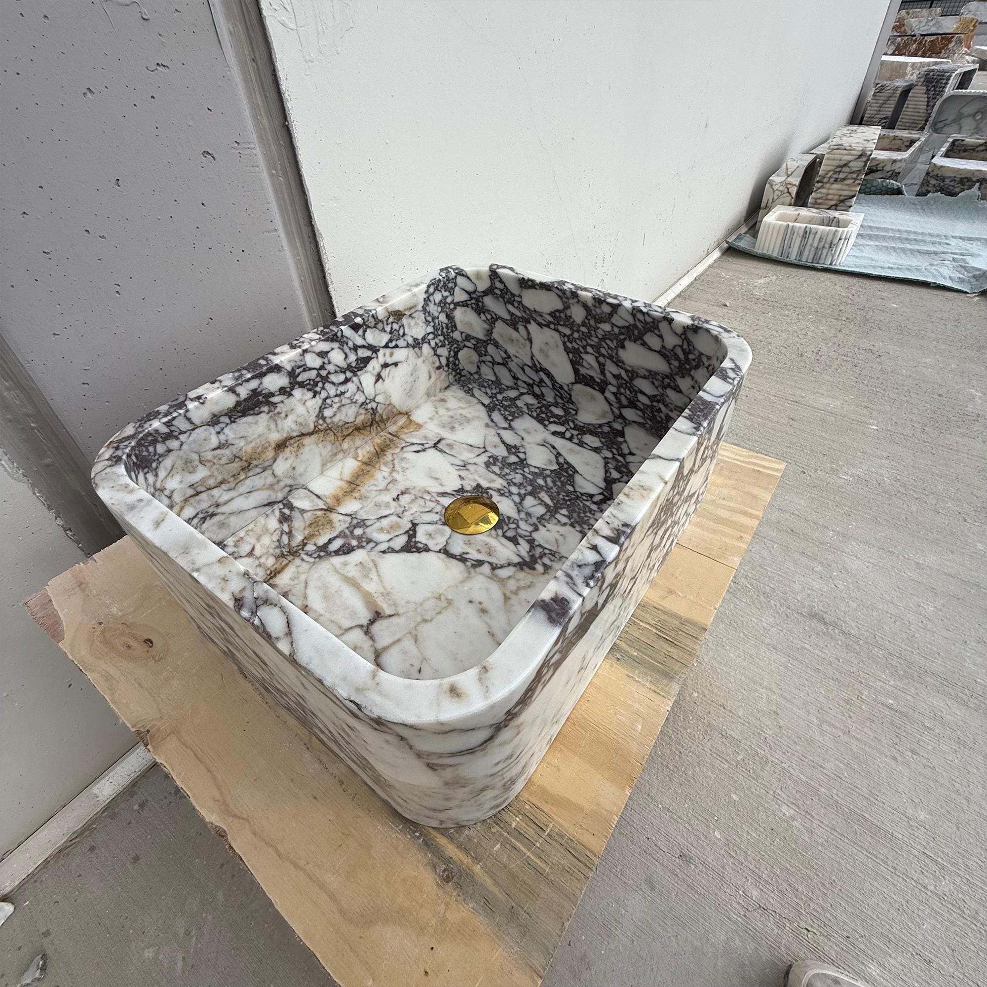 Designer marble sink placed on wooden platform