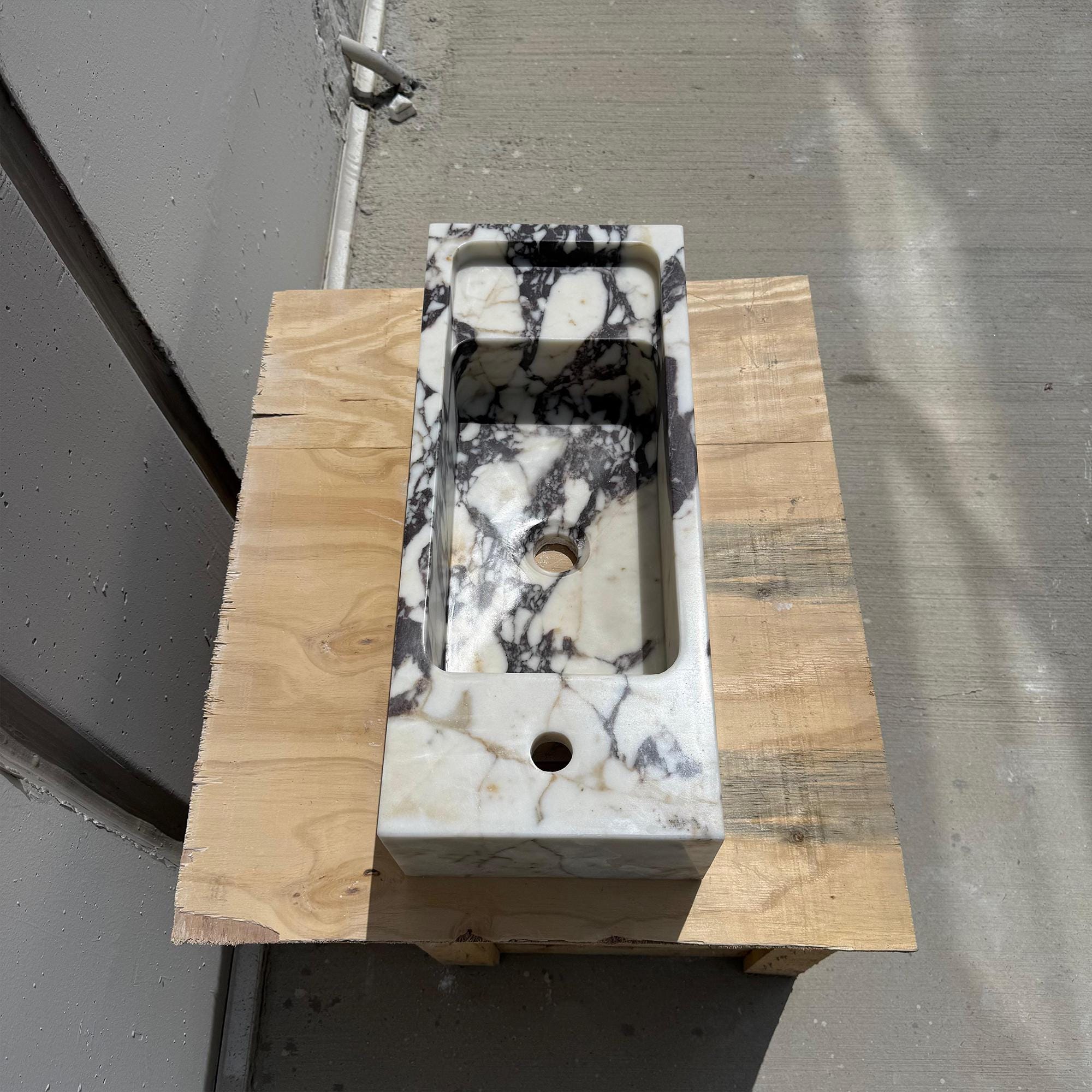 A solid marble vanity sink with a contemporary form, perfect for elegant and compact interior designs.