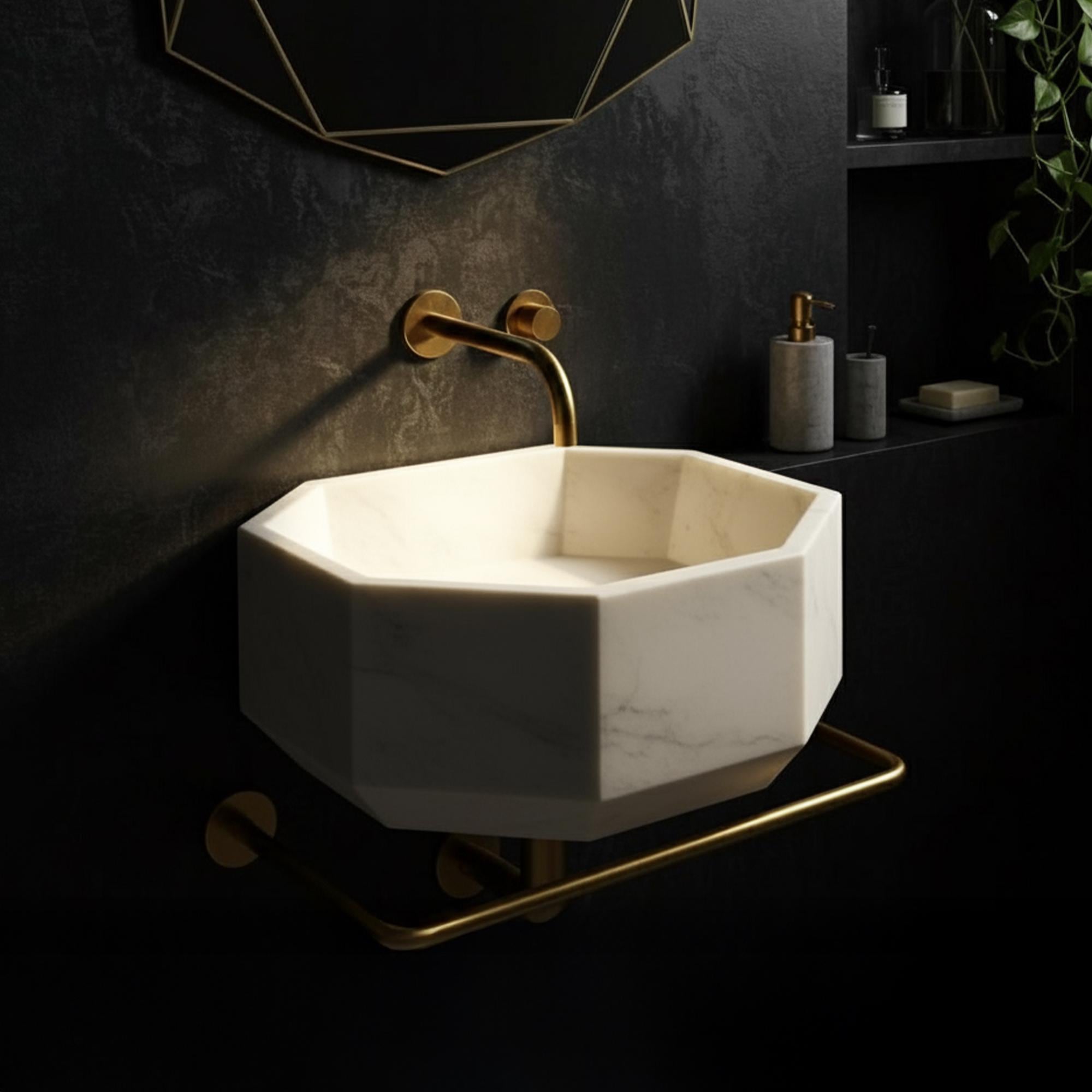 Sculptural white marble basin in octagonal form, paired with luxurious gold bathroom fixtures.