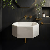 Elegant white marble pedestal sink with geometric design and minimalist wall tap setup.