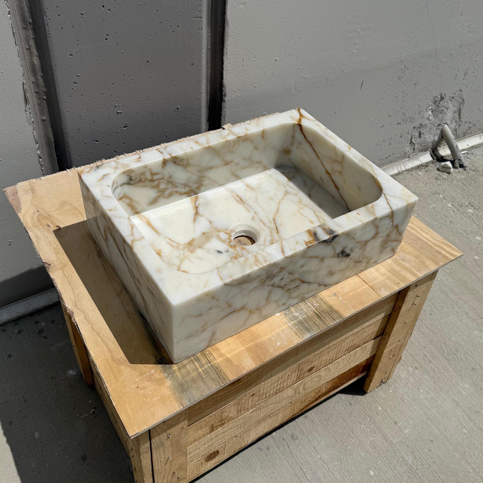 Premium compact stone sink displayed on wooden crate in sunlight