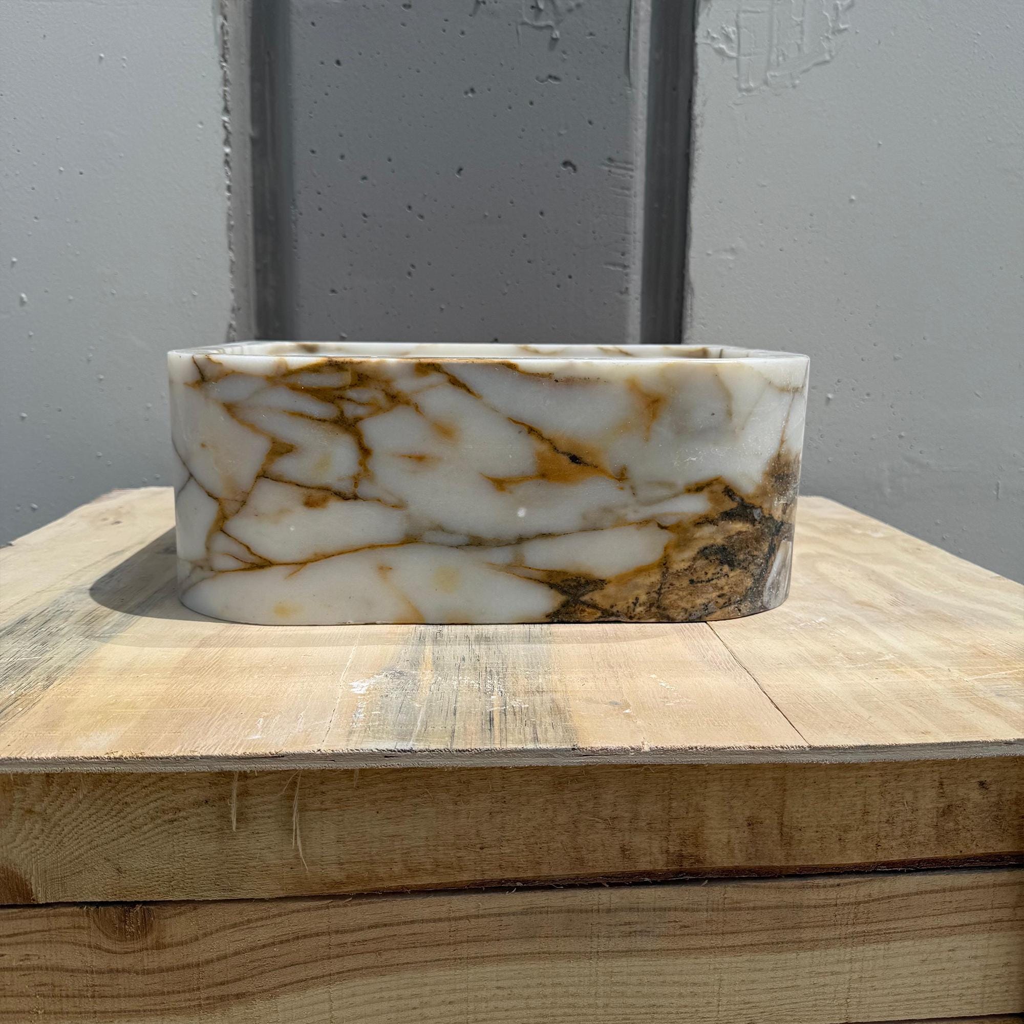 Calacatta Gold marble powder room sink on wooden display base