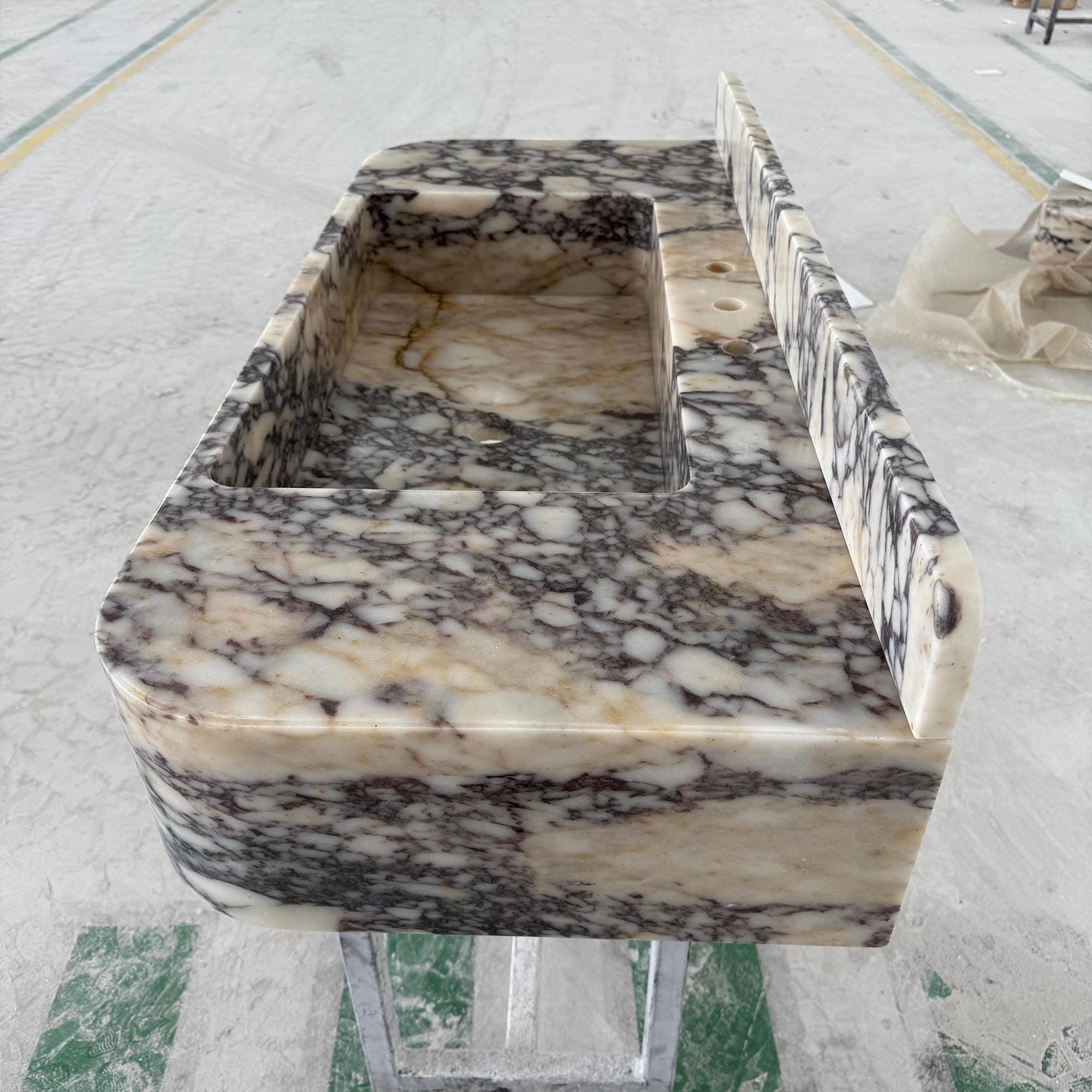 Custom-designed stone sink made from Calacatta Viola marble for upscale bathrooms.