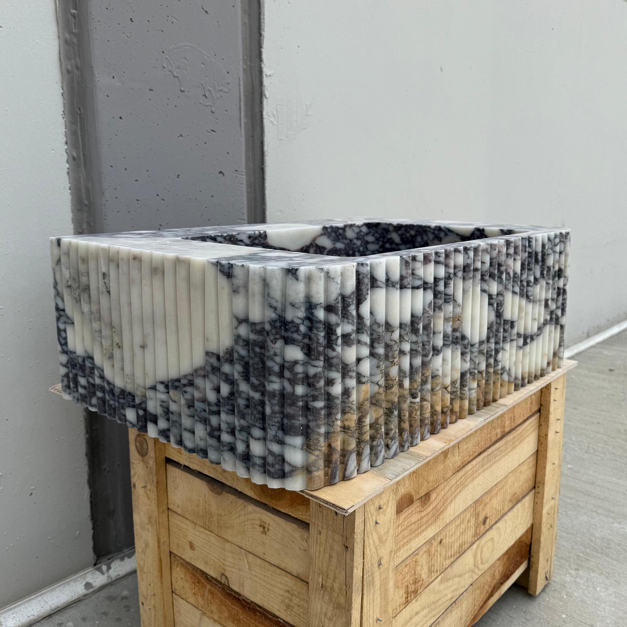 Unique marble vanity sink with dramatic color contrast and ribbed carving