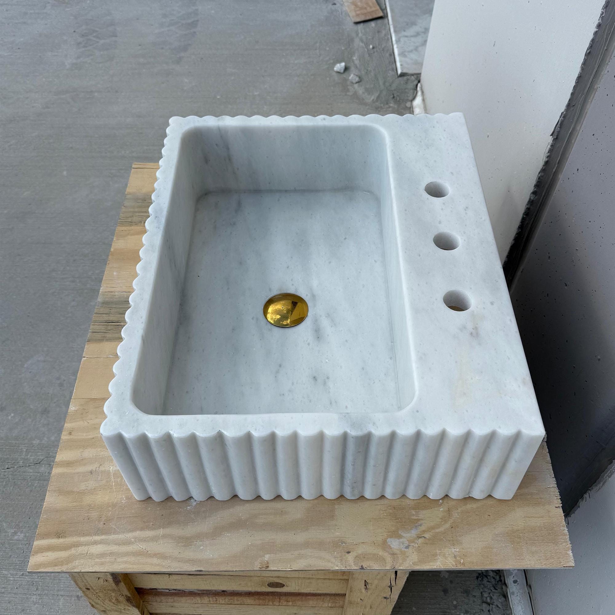 Classic Carrara sink featuring three faucet holes on vanity slab