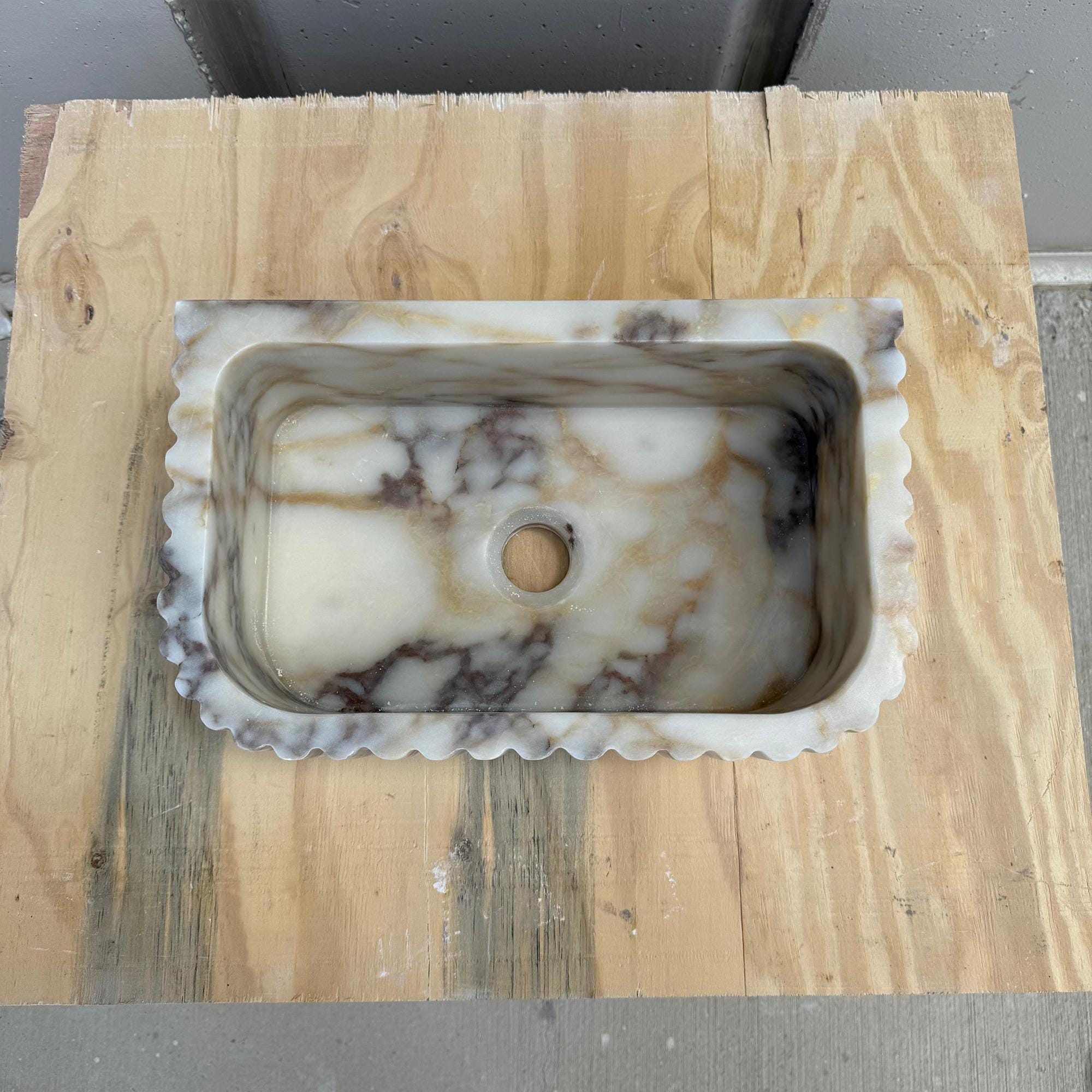 This handcrafted Carrara marble sink blends classic texture with modern elegance.