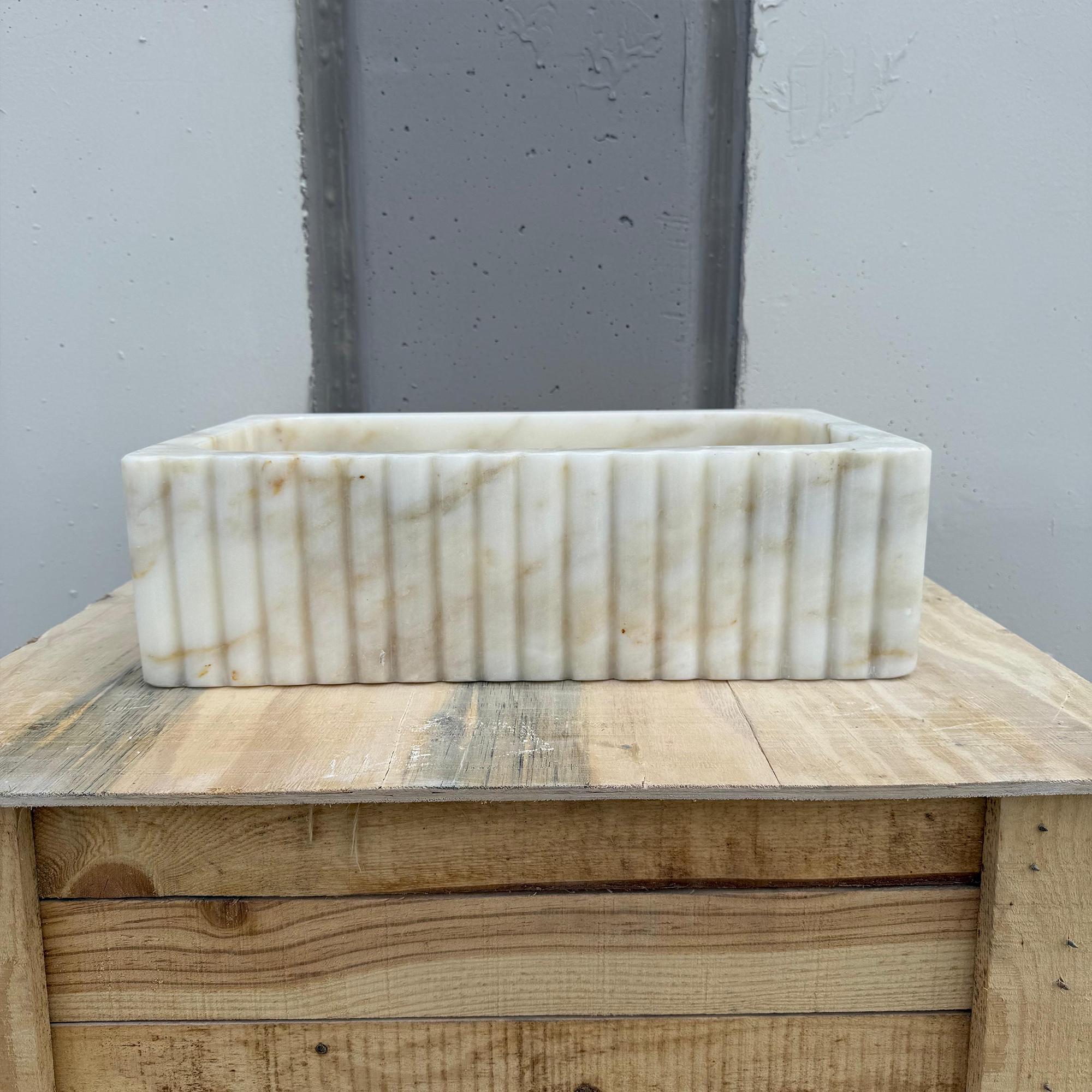 Natural stone sink featuring clean lines and soft veining.