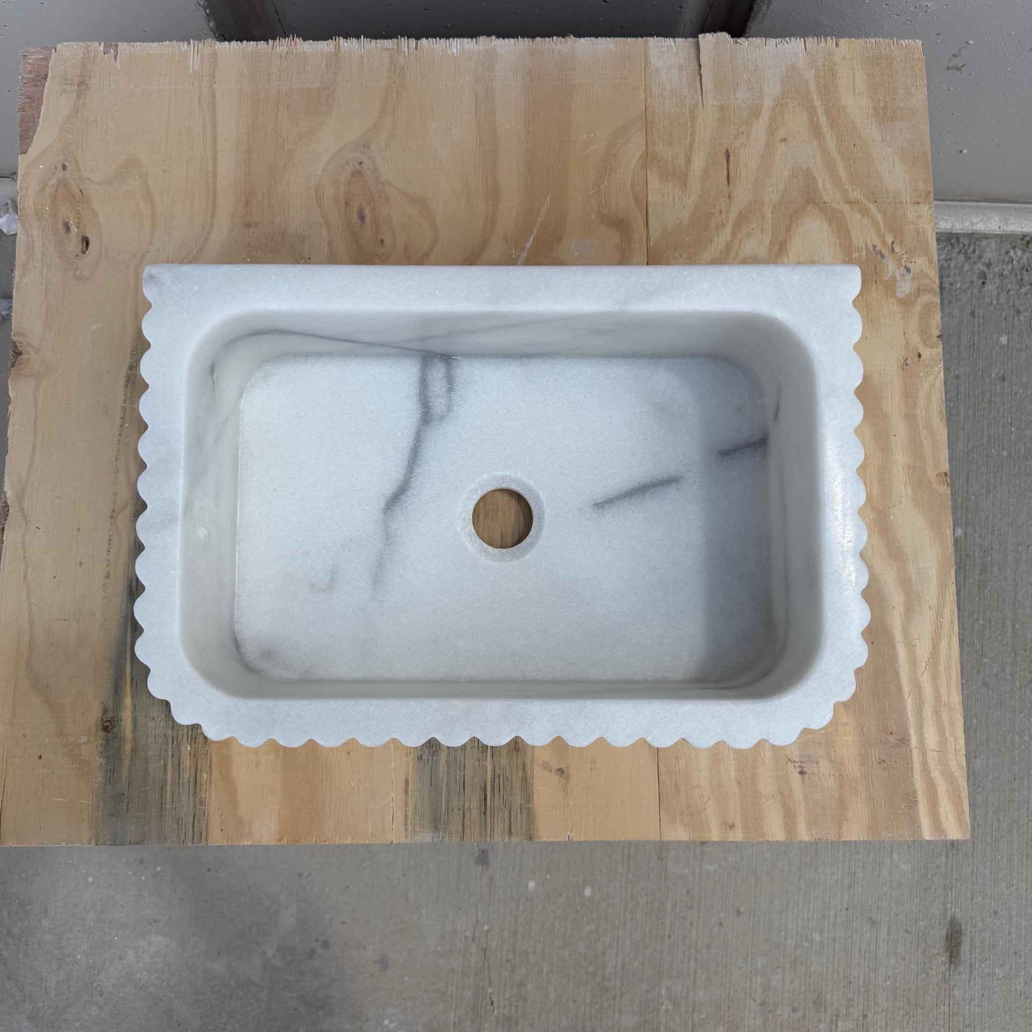 Handcrafted fluted Carrara marble bathroom sink in natural light