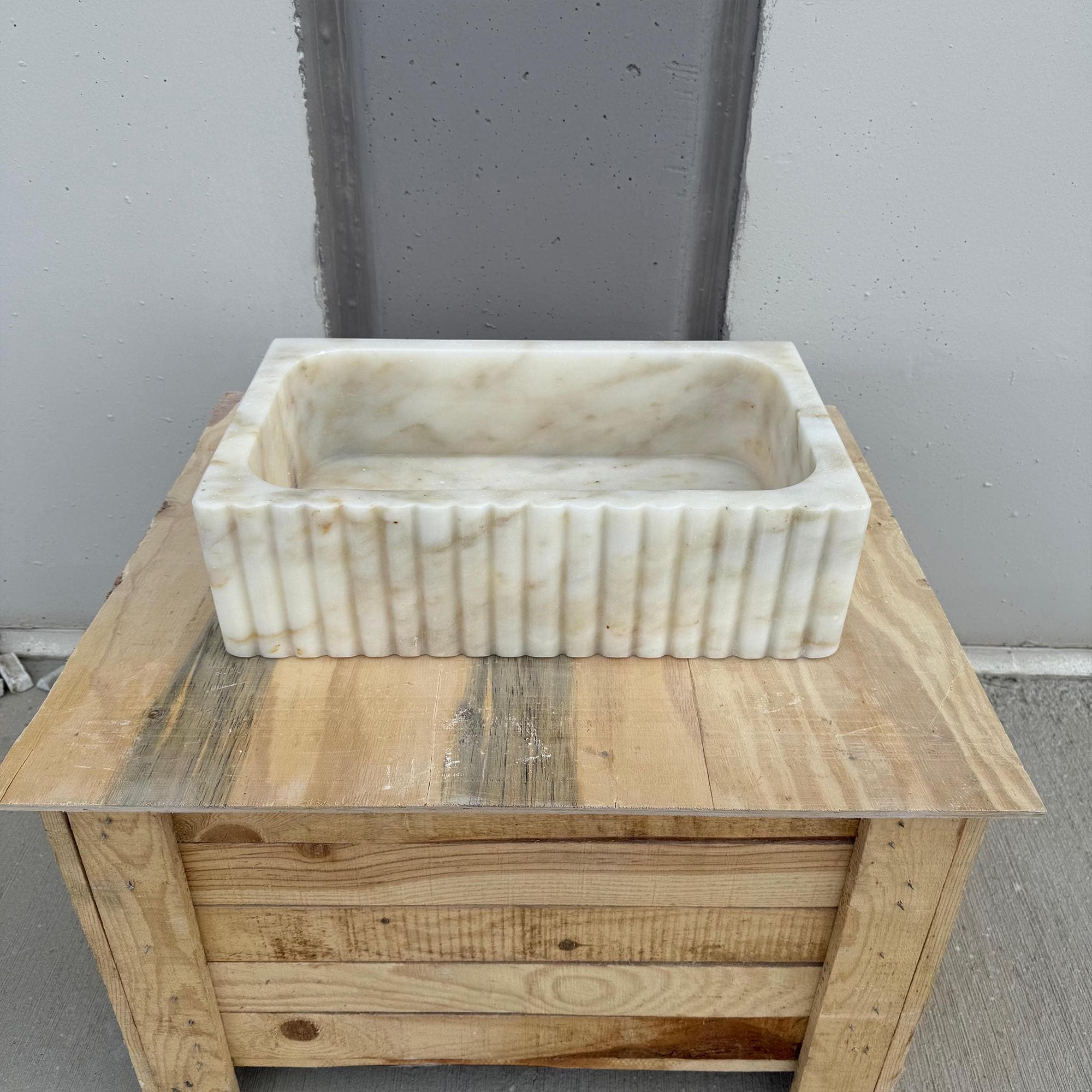 Handcrafted rectangular sink with carved fluted marble design.