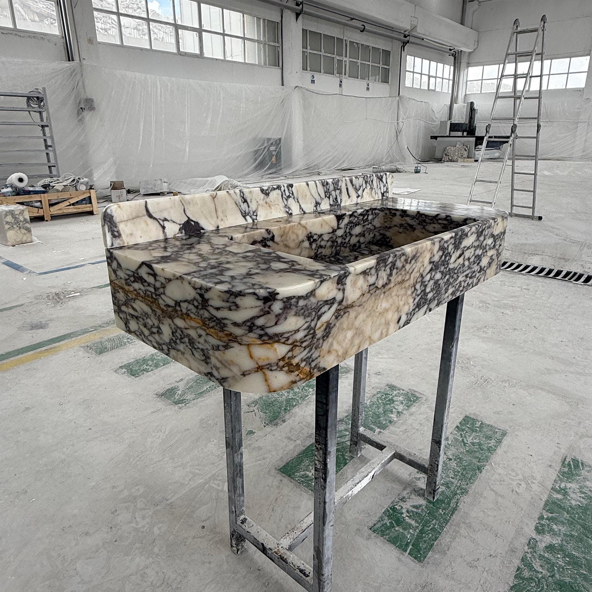 A handcrafted marble basin with dramatic black and cream veining.