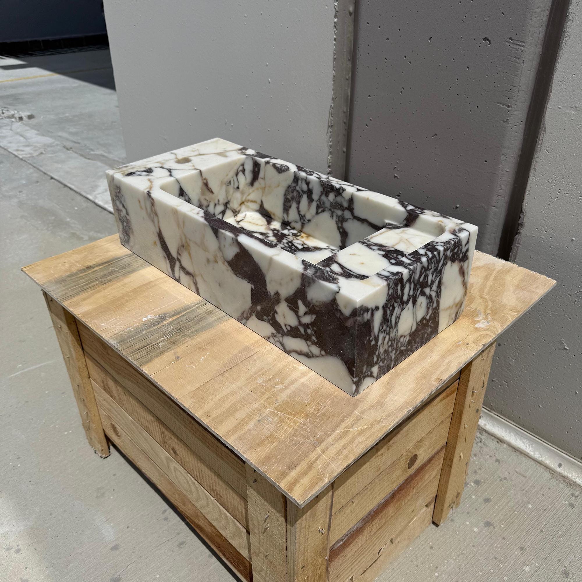 The sink showcases a minimalist rectangular design with distinctive marble patterns and rich textures.