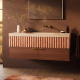Pink fluted marble sink wall-mounted above floating wooden vanity drawers