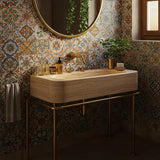 A luxurious travertine stone sink with a golden metal frame in a Mediterranean-style bathroom.