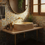 A hand-carved travertine sink rests on a natural wood vanity in a rustic Mediterranean bathroom.
