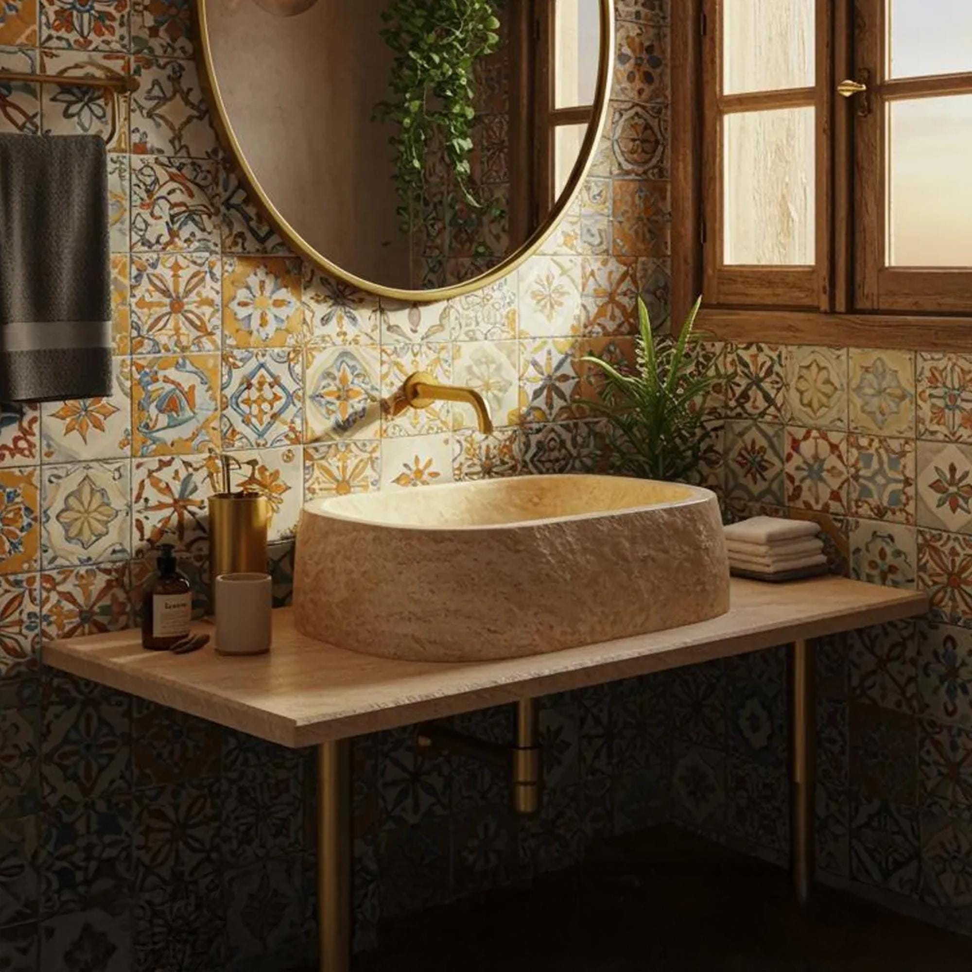 A hand-carved travertine sink rests on a natural wood vanity in a rustic Mediterranean bathroom.
