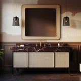 A wide vanity with a bold red marble top and woven rattan cabinet base creates a luxurious bathroom focal point.